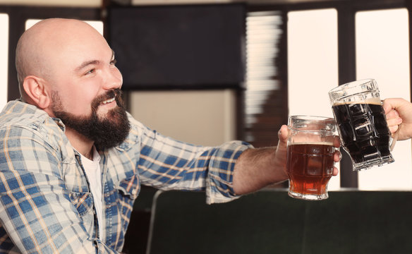 Man cheering with glasses of beer in pub