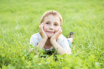 Portrait of a smiling boy on a background of green grass
