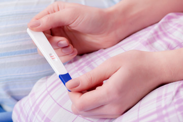 Obraz na płótnie Canvas Woman discovering her positive pregnancy test