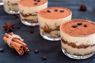 luxurious dessert Tiramisu in a glass with coffee beans on a dark background