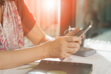 woman hand sitting on working table and using smartphone ,for people modern lifestyle theme