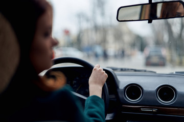 woman driving a car, a rear-view mirror