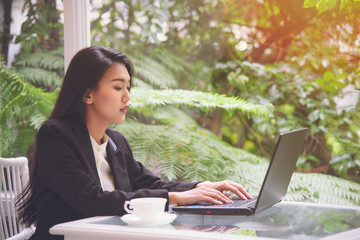 Beautiful young business woman working with a laptop, looking at screen with a gesture of rejoicing, shock, surprise emotion