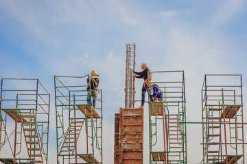 Construction workers working on scaffolding at a high level by the standards set must include a safety belt for safety. Heavy industry and Safety at Work concept.