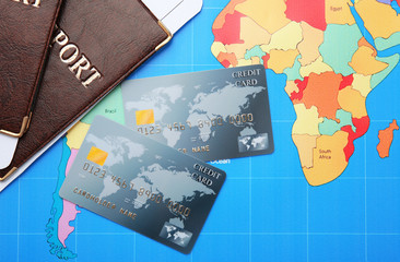 Credit cards with passports and tickets for vacations on world map background