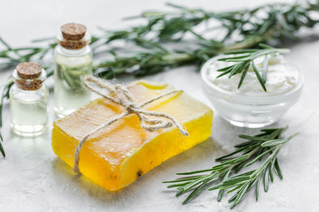 close up body care rosemary cosmetic products on stone background