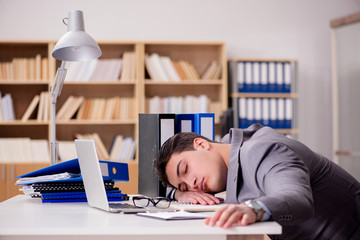 Obraz premium Sleepy businessman working in office