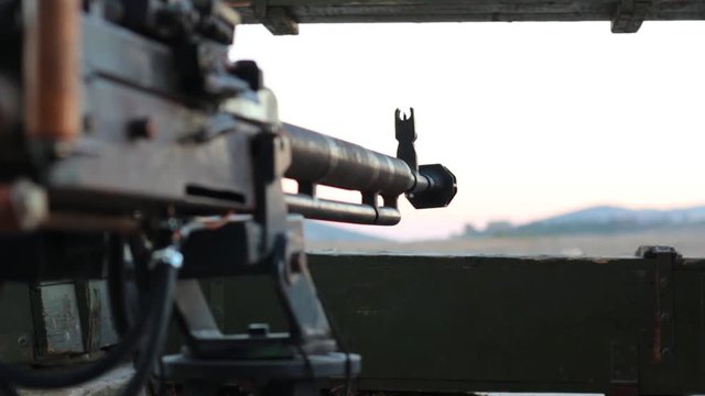 Heavy machine gun in the trenches. War in real time. Focus on the barrel gun