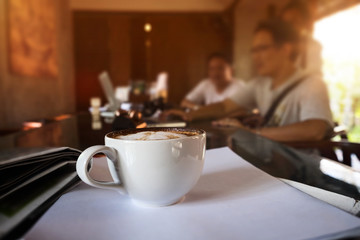 Close up at cup of coffee, business meeting at coffee shop.