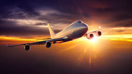 Fototapeta na wymiar Airplane flying during sunset