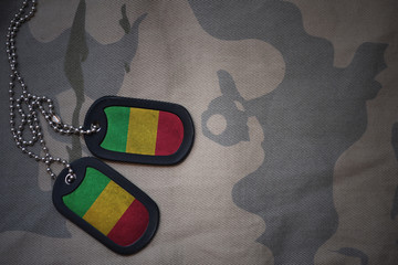 army blank, dog tag with flag of mali on the khaki texture background. military concept