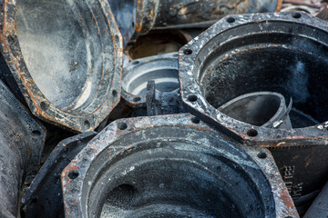 Close up of a dump of old rusty pipes and metal tubes with a holes in it for a screw.