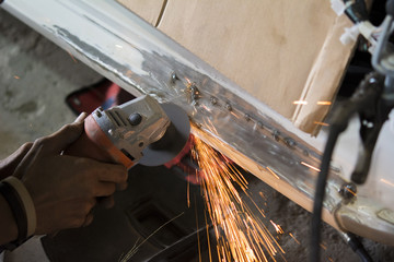 Mechanic grinding car body by grinder