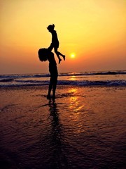 Fototapeta na wymiar mother and child silhouette in the beach sunset