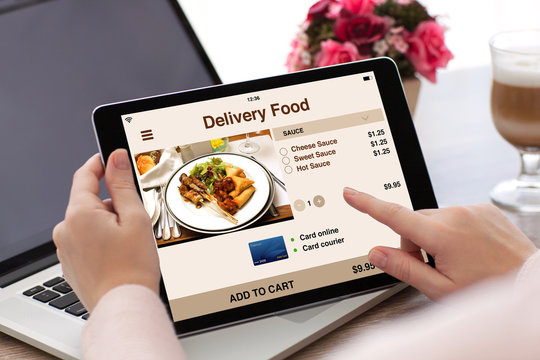woman hands holding tablet computer with app delivery food screen