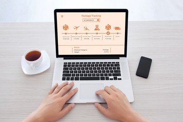 Fototapeta premium male hands typing on laptop keyboard with package delivery tracking