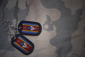 army blank, dog tag with flag of swaziland on the khaki texture background. military concept