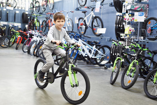 Boy riding bicycle in sports supermarket