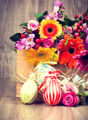 Easter eggs with flowers on wooden background