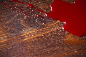 A puddle of blood on a wooden background