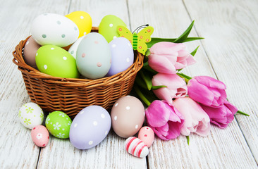 Obraz na płótnie Canvas Basket with easter eggs and tulips