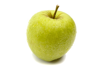 A brightly green apple in droplets of dew isolated on a white background.