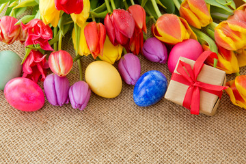 Obraz na płótnie Canvas Spring tulips with colorful easter eggs and gift box.