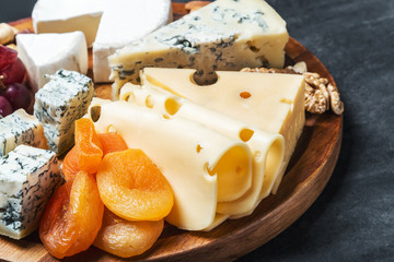 Assorted cheeses with grapes and nuts on table