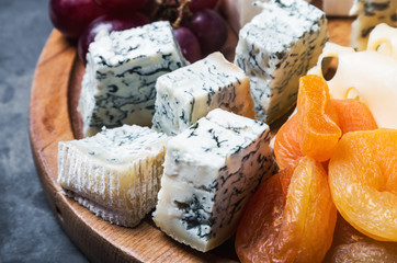 variety of cheeses with grapes and dried fruits
