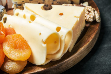 variety of cheeses with grapes and dried fruits