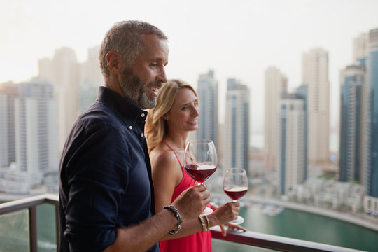 Couple drinking wine at balcony.