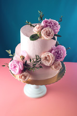 Pink cream wedding cake decorated with fresh roses