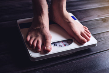 Women's feet are on mechanical scales for weight control