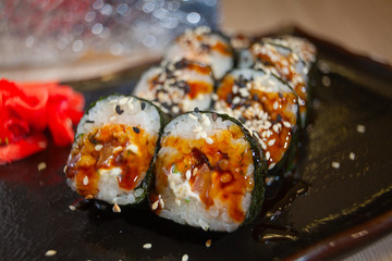 Japanese rolls with eel on black plate