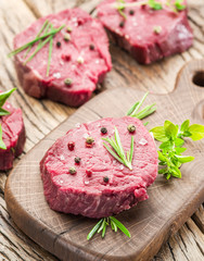 Pieces of beef tenderloin on the wooden cutting board.