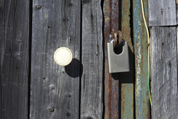 Padlock on an old wooden door.