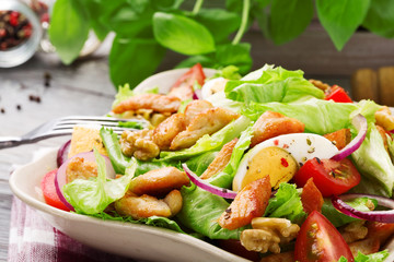 Delicious salad with chicken, nuts, egg and vegetables.