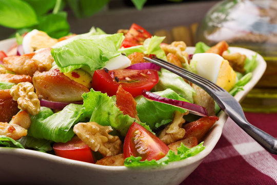 Delicious salad with chicken, nuts, egg and vegetables.
