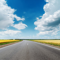 asphalt road under clouds in blue sky