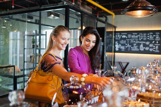 Smiling women selecting food at buffet table in restaurant