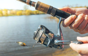 Girl's hand holding a fisherwoman spinning. The concept of fishing on a spinning