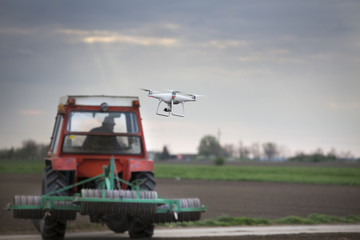 Obraz na płótnie Canvas Drone flying in front of tractor