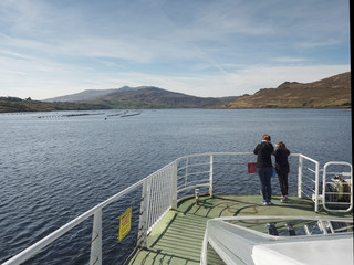 Fototapeta premium Mother and daughter looking at a mussels farm in a fjord from a bow of a cruise ship.
