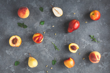 Fototapeta na wymiar Fresh peaches and pears on dark background. Flat lay, top view
