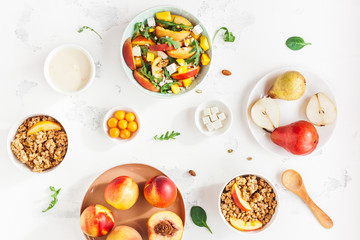 Breakfast with muesli, peach salad, fresh fruit, yogurt on white background. Healthy food concept. Flat lay, top view