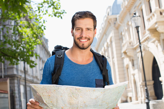 Portrait of young man holding map.
