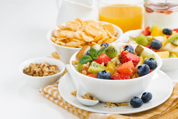 breakfast with fruit salad and corn flakes on white table
