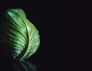 Fresh cabbage on black background with copy space. Vegan concept.