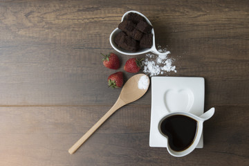 Coffee cup on wood table and cookie brownie.