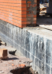 Close up on Waterproofing and insulation house foundation wall. Foundation Waterproofing and Damp proofing Coatings. Waterproofing house foundation with bitumen  spray on tar